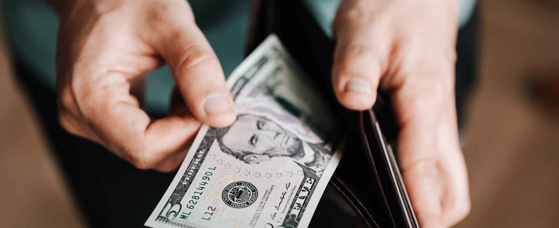 unrecognizable man holding wallet with money